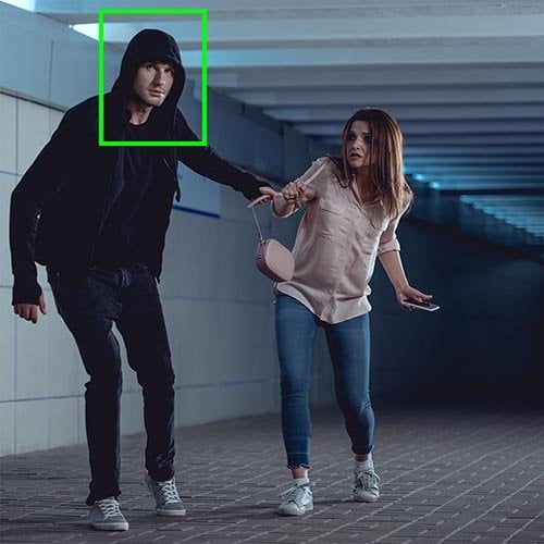Security camera footage with facial recognition boxes tracking people in a public space.