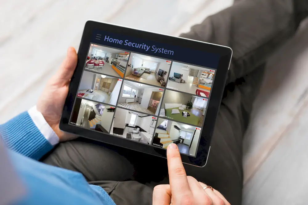 Person looking at home security monitoring on a tablet.
