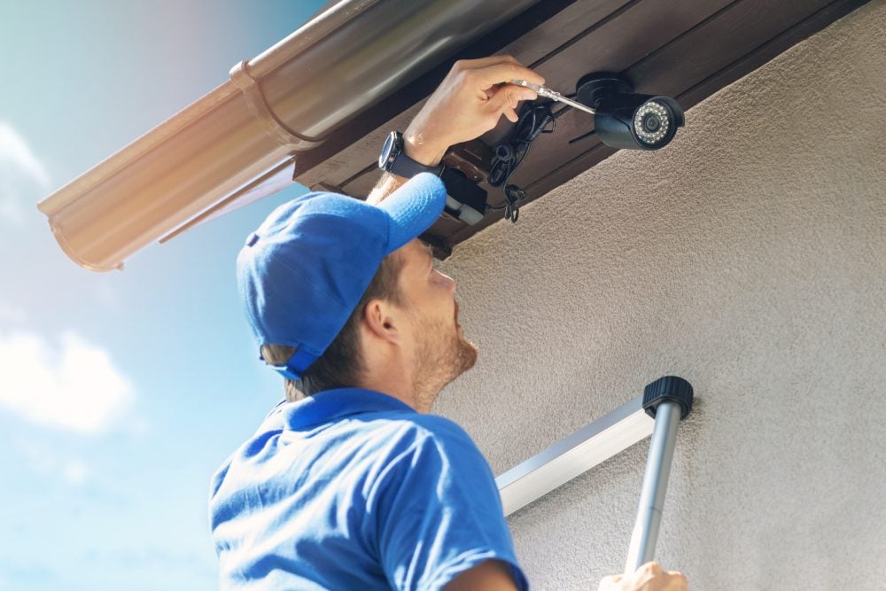A man installing an outdoor IP security camera