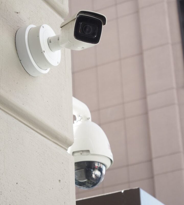 A security camera on the outside of an apartment building.