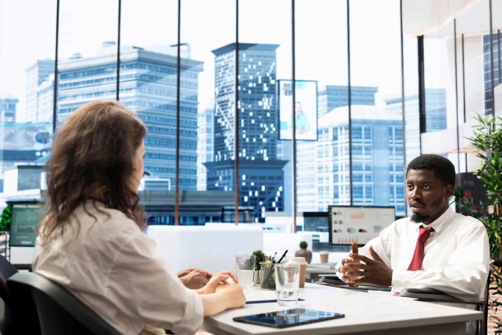 A businessowner talking with an employee in their office.