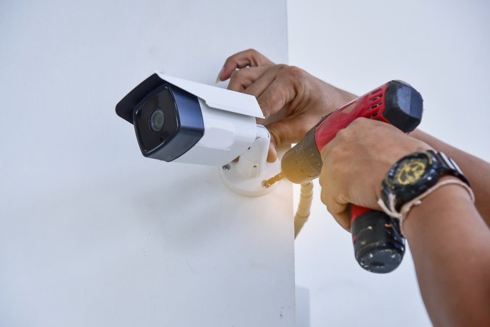 A technician installing an outdoor camera.